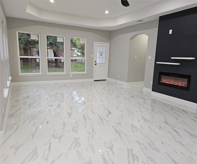 unfurnished living room with a raised ceiling