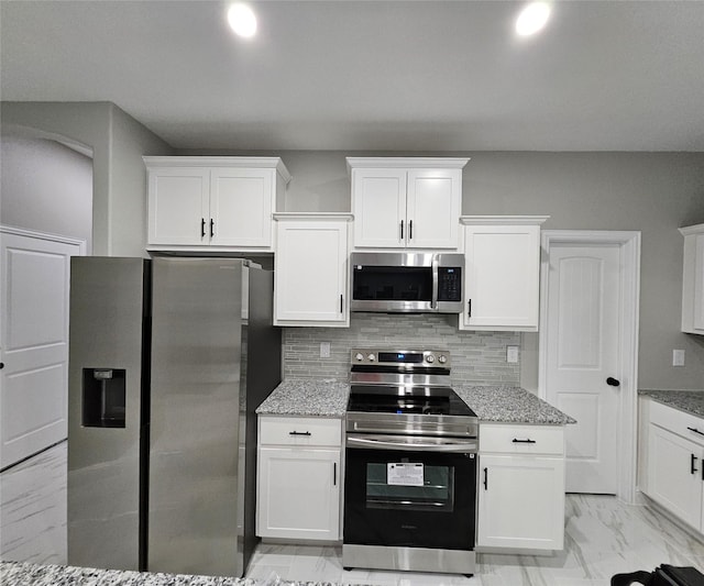 kitchen featuring tasteful backsplash, white cabinetry, and appliances with stainless steel finishes