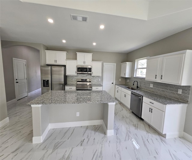 kitchen featuring sink, a center island, white cabinets, and appliances with stainless steel finishes