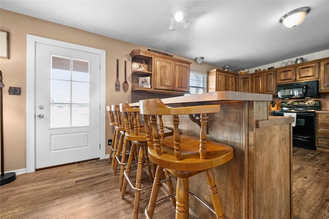 kitchen with black appliances and dark hardwood / wood-style floors