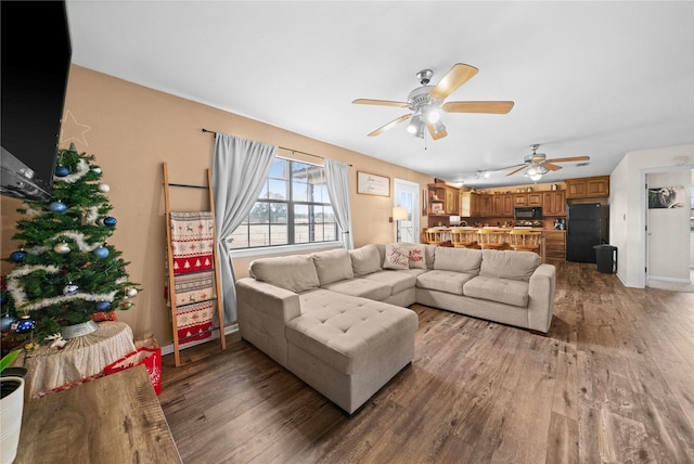 living room featuring wood-type flooring and ceiling fan