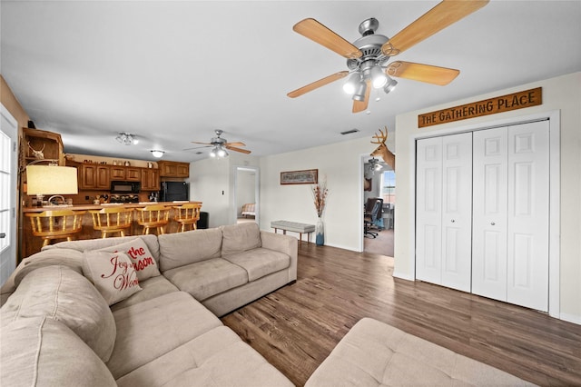 living room featuring hardwood / wood-style floors and ceiling fan