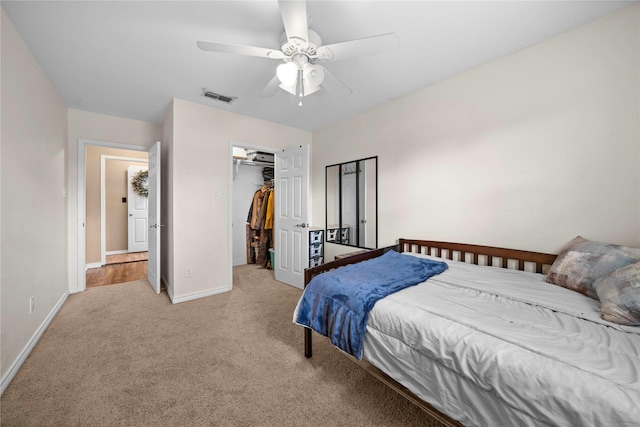 bedroom with ceiling fan, light colored carpet, and a closet