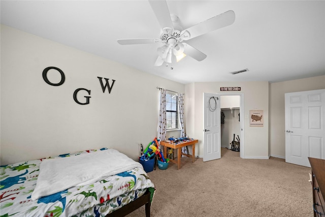 carpeted bedroom featuring ceiling fan, a walk in closet, and a closet