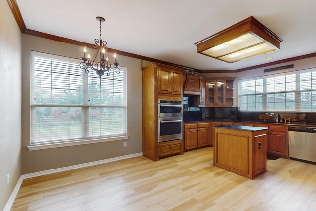 kitchen with a center island, stainless steel appliances, a notable chandelier, pendant lighting, and light wood-type flooring