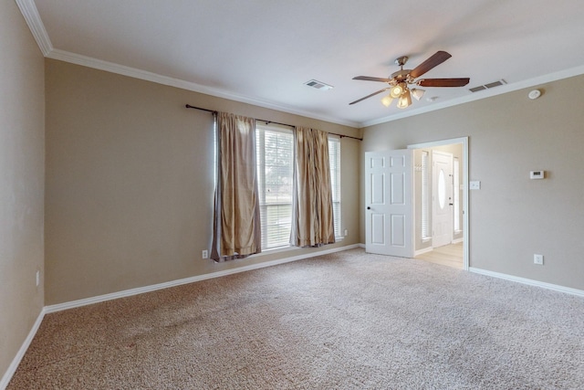 carpeted spare room with ceiling fan and crown molding