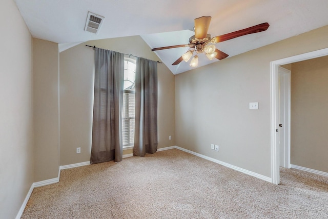 unfurnished room featuring ceiling fan, a healthy amount of sunlight, light carpet, and vaulted ceiling