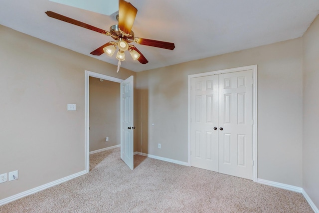 unfurnished bedroom featuring ceiling fan, a closet, and light colored carpet