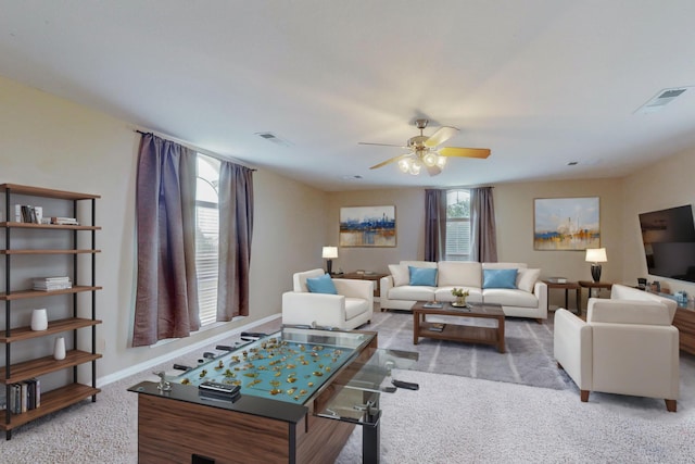 carpeted living room with ceiling fan