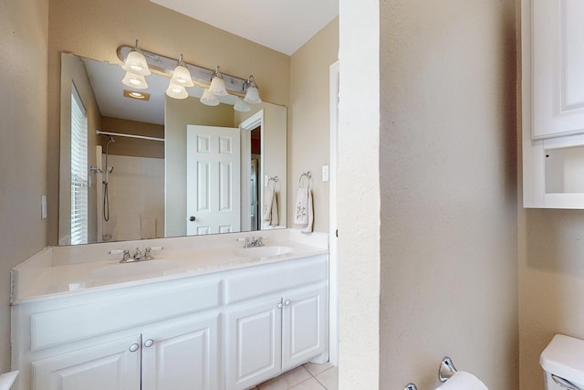 bathroom featuring a shower, tile patterned flooring, vanity, and toilet