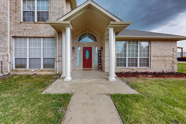 entrance to property with a lawn