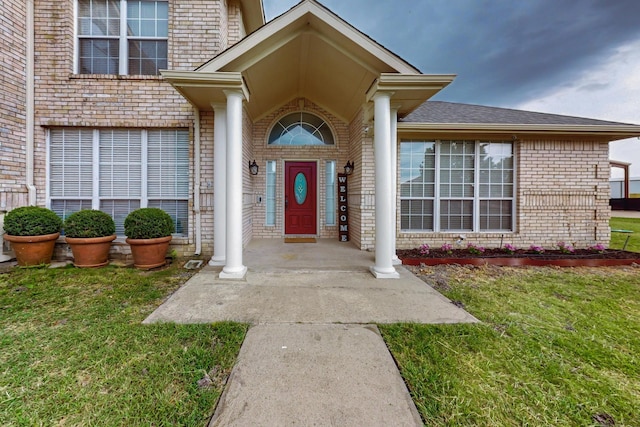 view of exterior entry with a yard