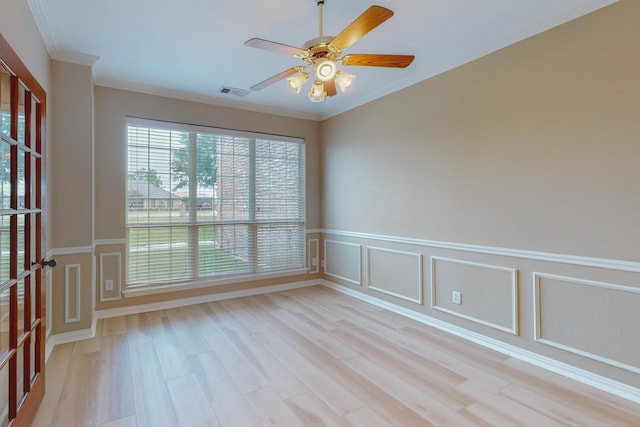 empty room with ceiling fan, light wood-type flooring, and ornamental molding