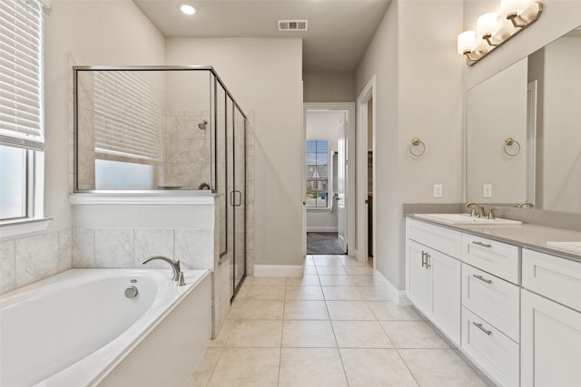 bathroom featuring tile patterned flooring, vanity, and plus walk in shower