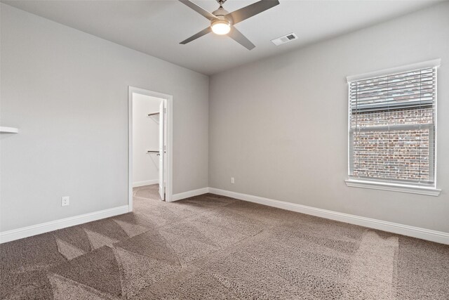 spare room featuring ceiling fan, carpet, and a healthy amount of sunlight