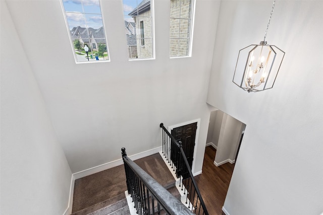 staircase with a chandelier and wood-type flooring