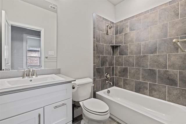 full bathroom featuring vanity, tiled shower / bath combo, and toilet