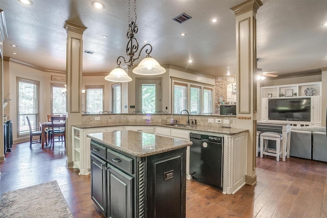 kitchen featuring a center island, sink, black dishwasher, decorative light fixtures, and decorative columns