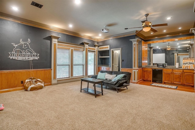 living room with ceiling fan, light colored carpet, ornate columns, and ornamental molding