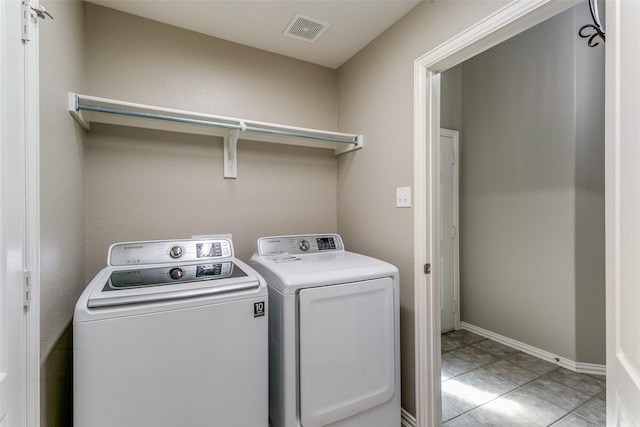 laundry area featuring washing machine and dryer and light tile patterned floors