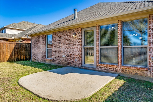 back of property with a yard and a patio