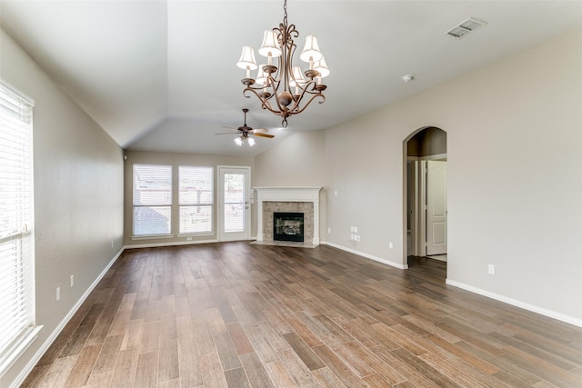 unfurnished living room featuring lofted ceiling, wood-type flooring, ceiling fan with notable chandelier, and a tiled fireplace