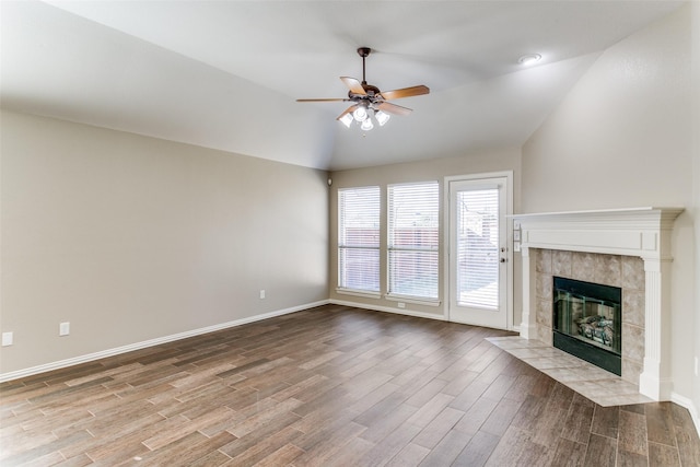 unfurnished living room with a tile fireplace, light wood-type flooring, ceiling fan, and lofted ceiling