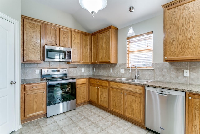 kitchen with tasteful backsplash, stainless steel appliances, vaulted ceiling, sink, and pendant lighting