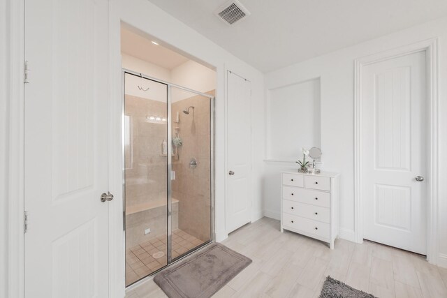 bathroom featuring a shower with door