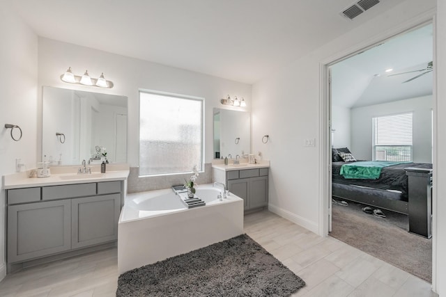 bathroom featuring vanity, ceiling fan, and a bathing tub