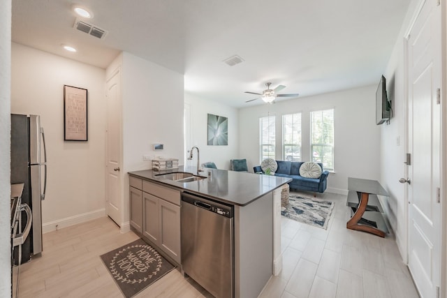 kitchen with kitchen peninsula, ceiling fan, sink, and stainless steel appliances