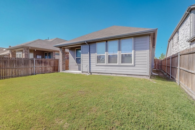 rear view of property featuring a lawn