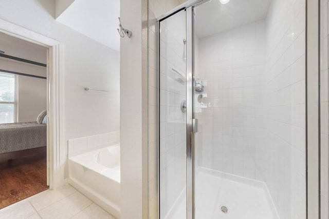 bathroom with independent shower and bath and tile patterned flooring