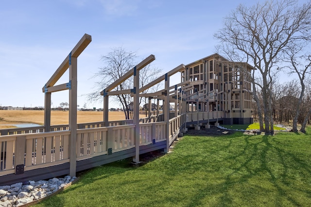 exterior space featuring a lawn and a deck with water view