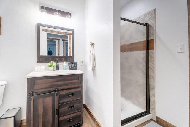 bathroom featuring vanity, an enclosed shower, and toilet