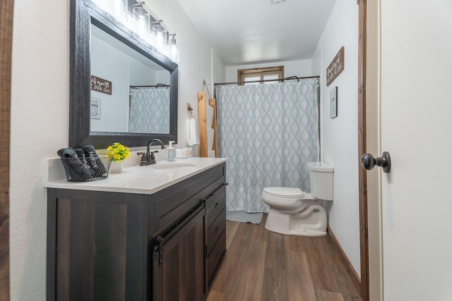 bathroom with hardwood / wood-style floors, vanity, and toilet