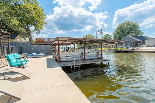 dock area featuring boat lift, a water view, and fence