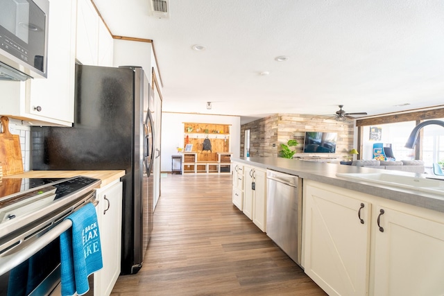 kitchen with stainless steel appliances, plenty of natural light, hardwood / wood-style flooring, and sink