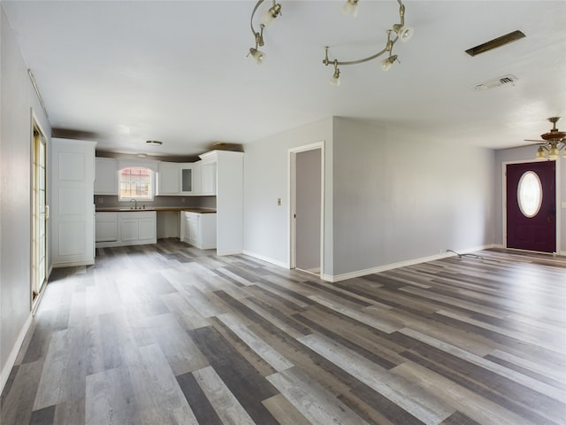 unfurnished living room featuring ceiling fan, dark hardwood / wood-style flooring, and sink