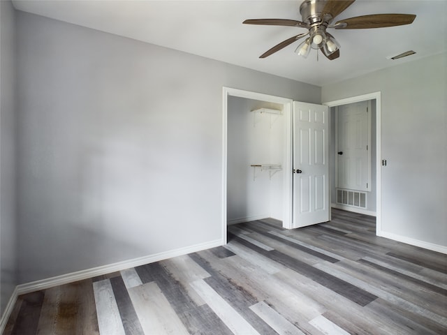 unfurnished bedroom featuring ceiling fan, a closet, and hardwood / wood-style flooring