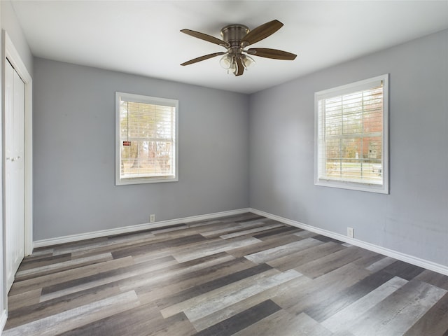 empty room with dark hardwood / wood-style floors and ceiling fan