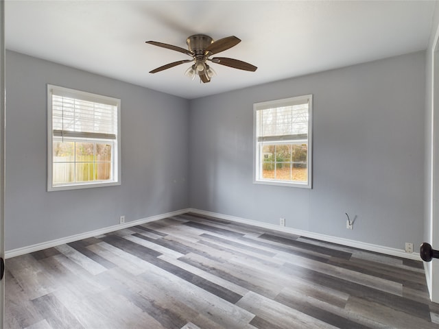 spare room with ceiling fan, dark wood-type flooring, and a wealth of natural light