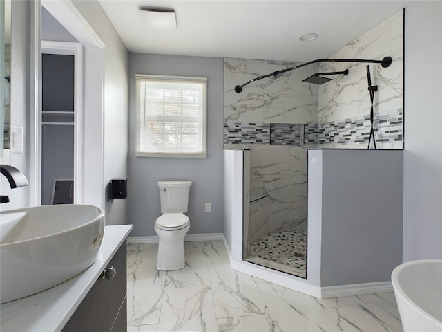 bathroom with tiled shower, vanity, and toilet