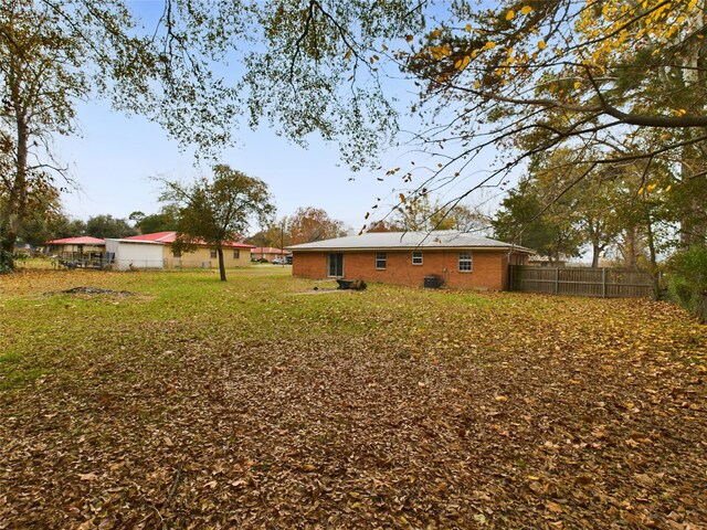 rear view of house featuring a yard and central air condition unit