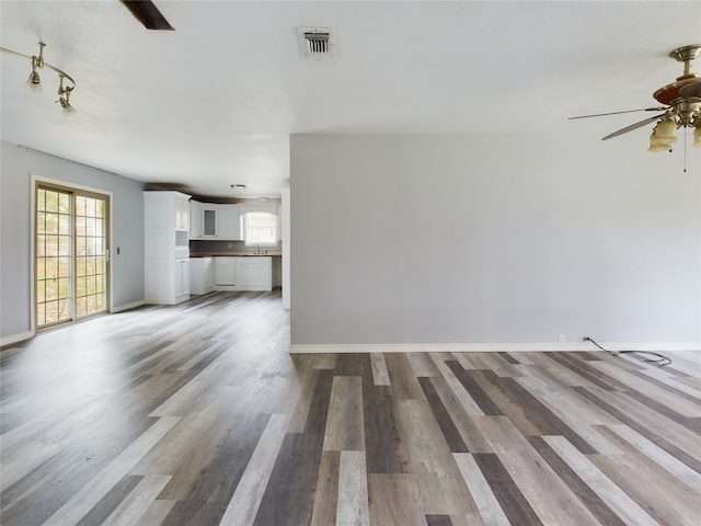 unfurnished living room featuring hardwood / wood-style floors and ceiling fan