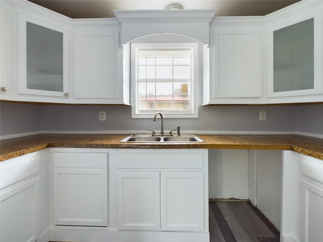 kitchen featuring dark hardwood / wood-style flooring, white cabinetry, and sink