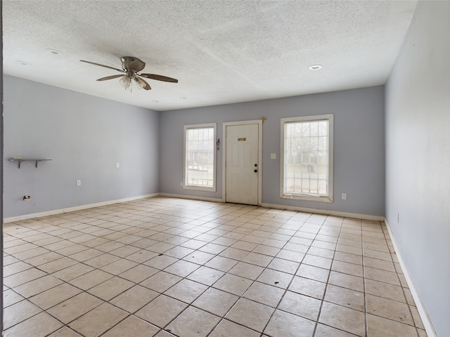 entryway with ceiling fan, light tile patterned flooring, and a textured ceiling