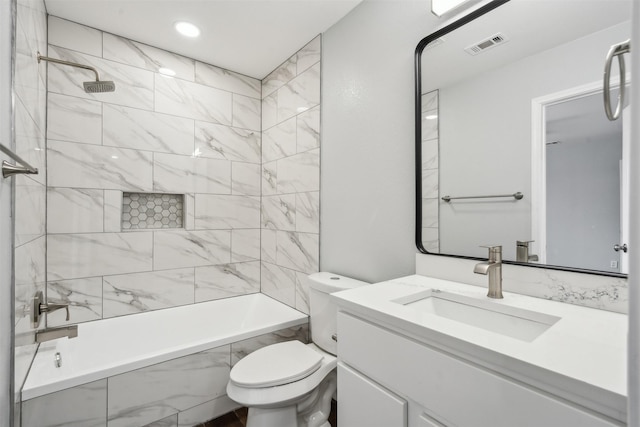 full bathroom with vanity, tiled shower / bath combo, and toilet