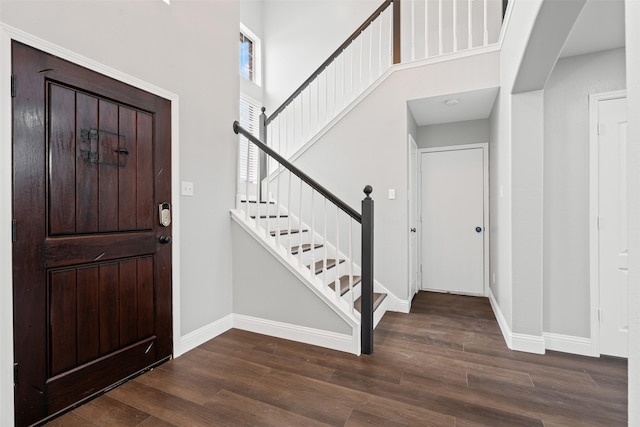 foyer with dark hardwood / wood-style flooring and a towering ceiling