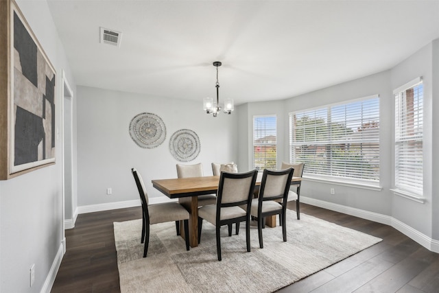 dining room featuring dark wood-type flooring and a chandelier